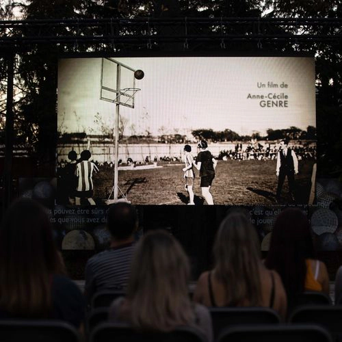 Projection en plein air d'un film sur le sport féminin lors d'un événement culturel